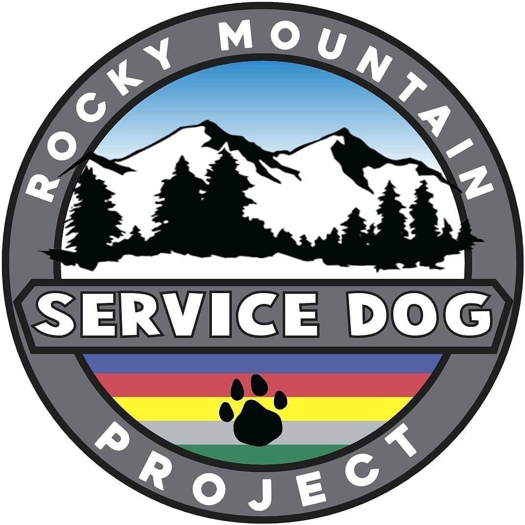 Mountain range with trees, blue sky, and a black paw print below the text 'SERVICE DOG'.