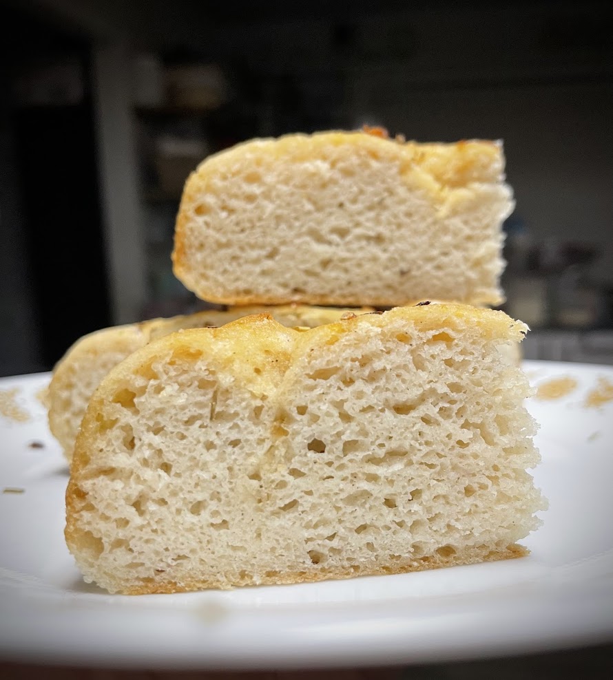 Two slices of bread stacked on a white plate, with a blurred kitchen background.