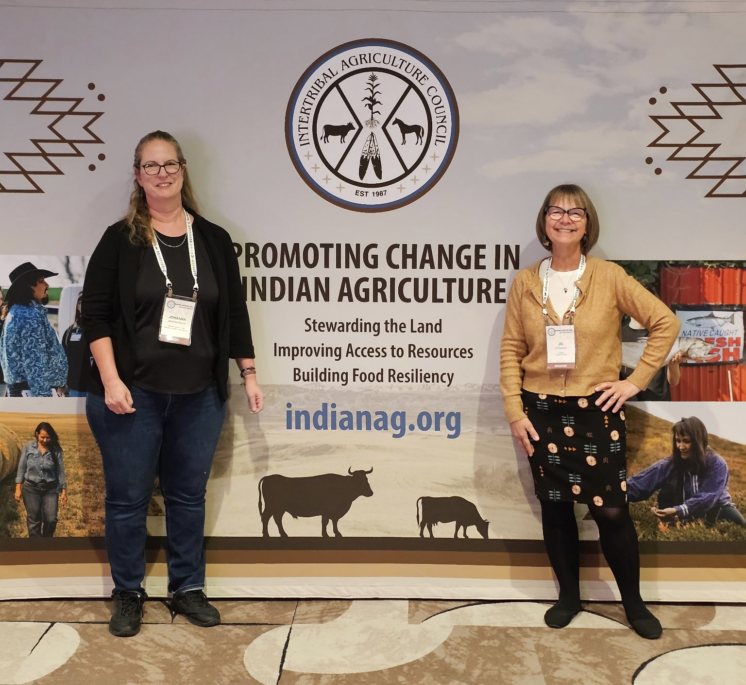 Two women standing in front of a banner with the International Agribusiness logo and text about Indian agriculture.