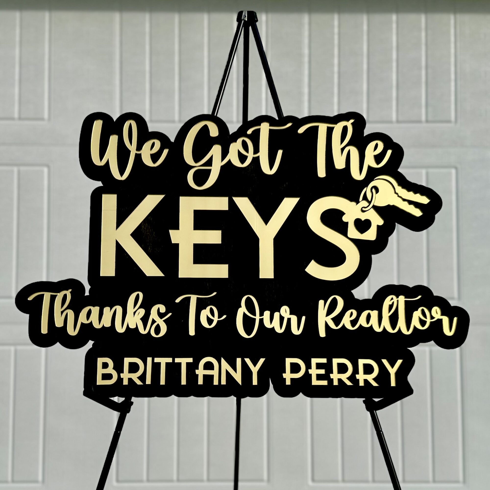 Sign with text thanking realtor Brittany Perry, featuring a key graphic and decorative script font.